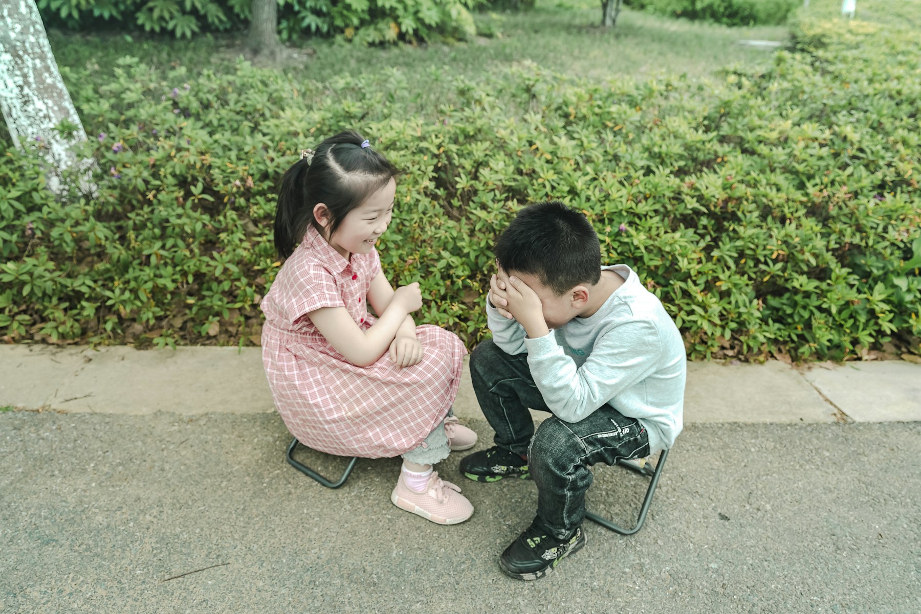A boy and a girl talking on a bench