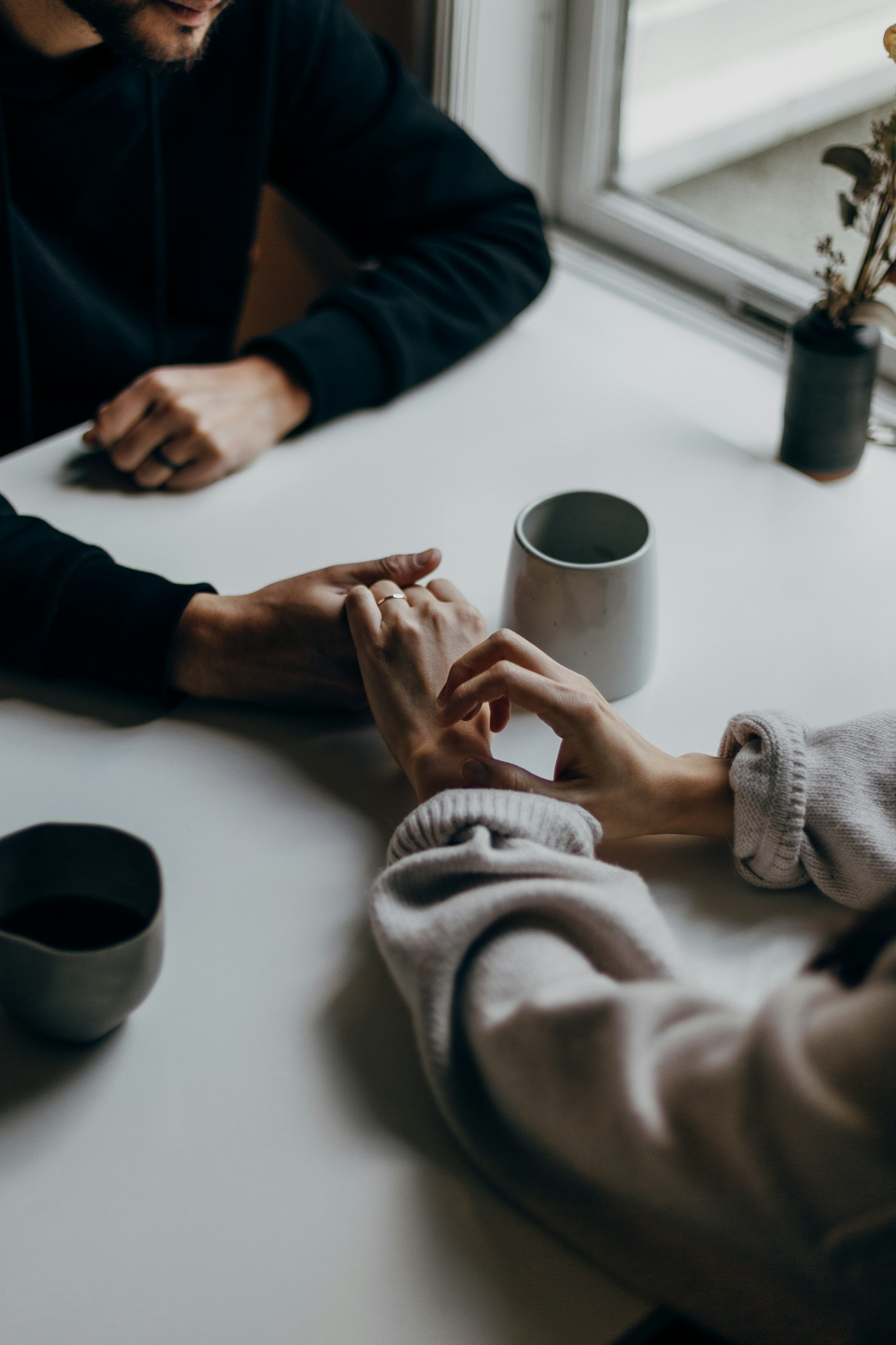 A couple holding hands across a table